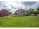 Spacious backyard features green lawn, wood deck, fire pit and two-story home at 3360 Main St, Plainfield, IN 46168