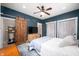 This bedroom features a sliding barn door, a ceiling fan, blue walls, and a bed with a blue quilt at 3360 Main St, Plainfield, IN 46168