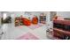 This bonus room features orange chairs, pink rugs, books and white floors at 3360 Main St, Plainfield, IN 46168