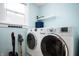 Bright laundry room features a washer and dryer, storage shelf, window and vacuum cleaner at 3360 Main St, Plainfield, IN 46168