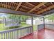 Covered back porch with wood railings and view of fenced-in backyard, trampoline and detached garage at 3409 S Rural St, Indianapolis, IN 46237
