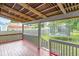 Covered back porch showcasing an outdoor space with wood railings, overlooking the backyard at 3409 S Rural St, Indianapolis, IN 46237