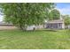 Backyard showcasing a trampoline, lush greenery, and a partial view of the home at 3409 S Rural St, Indianapolis, IN 46237