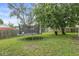 View of backyard with trampoline, mature trees, and grassy lawn at 3409 S Rural St, Indianapolis, IN 46237