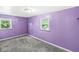 Vibrant bedroom with purple walls, two windows and carpeted flooring creates a cheerful atmosphere at 3409 S Rural St, Indianapolis, IN 46237