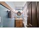 A charming bathroom with a wooden vanity, oval mirror, and blue tiled shower at 3480 W Broadus Dr, North Vernon, IN 47265