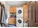 A well-organized laundry room features a stacked washer and dryer and custom wooden cabinetry at 3480 W Broadus Dr, North Vernon, IN 47265