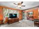 Bright living room showcasing orange walls, wood accents, and large window views at 3480 W Broadus Dr, North Vernon, IN 47265