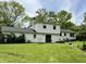 Expansive backyard with lush lawn, patio, and white home exterior with a black roof for outdoor enjoyment at 377 4Th E Ct, Carmel, IN 46033
