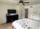 Bedroom with white walls, wood floors, and a black dresser featuring an electric fireplace at 377 4Th E Ct, Carmel, IN 46033