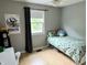 Bedroom with a twin bed, gray walls, and a window overlooking the yard at 377 4Th E Ct, Carmel, IN 46033