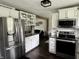 Kitchen with stainless steel refrigerator, stove, white cabinets, and granite countertops at 377 4Th E Ct, Carmel, IN 46033