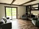 Bright living room with hardwood floors, exposed beams, fireplace with built-ins, and sliding doors to the outdoors at 377 4Th E Ct, Carmel, IN 46033
