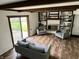 Bright living room with hardwood floors, exposed beams, fireplace with built-ins, and sliding doors to the outdoors at 377 4Th E Ct, Carmel, IN 46033