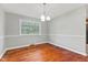 Dining area features hardwood floors, a chandelier, and a large window with natural light at 3841 S Sherman Dr, Indianapolis, IN 46237