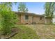 Single story home with stone exterior, small windows, patio and green lawn at 3841 S Sherman Dr, Indianapolis, IN 46237