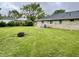 Large, private backyard featuring a lush green lawn and an outdoor fire pit, ideal for entertaining guests at 4004 N Ball Ave, Muncie, IN 47304