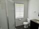 Well-lit bathroom featuring a shower, toilet, vanity, and window with blinds at 4004 N Ball Ave, Muncie, IN 47304