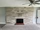 Close up on the stone fireplace with a gray carpet at 4004 N Ball Ave, Muncie, IN 47304