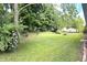 Tree-lined backyard with a lawn and a variety of plants at 403 Us Highway 31 N, Greenwood, IN 46142