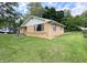 A lovely exterior view of the property showcasing its brick facade, manicured lawn, and serene natural surroundings at 403 Us Highway 31 N, Greenwood, IN 46142