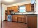 This eat-in kitchen features wood cabinets, stainless steel appliances, and hardwood-style flooring at 403 Us Highway 31 N, Greenwood, IN 46142
