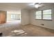 Open-concept living area with neutral carpeting, large windows, and a ceiling fan at 403 Us Highway 31 N, Greenwood, IN 46142