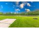 Serene backyard featuring lush greenery, a tranquil pond, and a concrete patio at 4056 Orchard Valley Ln, Indianapolis, IN 46235