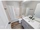 Well-lit bathroom featuring a shower-tub combo and modern sink vanity with wood-look flooring at 4056 Orchard Valley Ln, Indianapolis, IN 46235
