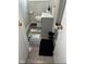 Compact bathroom with a gray vanity, modern toilet, and a mix of patterned and solid rugs at 4113 W 30Th St, Indianapolis, IN 46222