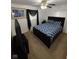 Comfortable bedroom with a dark wood bed frame, patterned bedding, a ceiling fan, and a TV at 4113 W 30Th St, Indianapolis, IN 46222