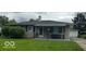 Charming single-story home boasts a well-manicured lawn and a welcoming front porch with an awning at 4113 W 30Th St, Indianapolis, IN 46222