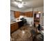Well-lit kitchen with wooden cabinets, black appliances, a glass dining table, and a glimpse of the living room at 4113 W 30Th St, Indianapolis, IN 46222