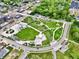 An aerial view displays the lush community park featuring a playground, walking paths, and a bridge in a vibrant neighborhood at 412 Sonhatsett Dr, Westfield, IN 46074