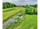 Lush green space with a stream, trees, and a building in the distance at 412 Sonhatsett Dr, Westfield, IN 46074