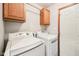 Laundry room with white washer and dryer and wooden cabinets above at 412 Sonhatsett Dr, Westfield, IN 46074