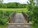Wooden bridge with yellow poles leading to a green field in the park at 412 Sonhatsett Dr, Westfield, IN 46074