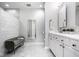 Bright bathroom featuring bench seating and a large vanity with modern fixtures at 435 Virginia Ave # 106, Indianapolis, IN 46203