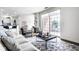 Bright living room with large window and stylish decor with a leather ottoman and decorative rug at 435 Virginia Ave # 106, Indianapolis, IN 46203