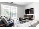 Comfortable living room featuring a view to the balcony, entertainment center, and stylish furniture at 435 Virginia Ave # 106, Indianapolis, IN 46203