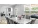 Bright dining room with marble table and grey chairs, connecting to the living room and featuring a window at 4689 Muscatine Way, Westfield, IN 46062