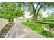 Spacious backyard with a long driveway leading to a detached garage, garden beds, and a hammock at 5148 Crittenden Ave, Indianapolis, IN 46205