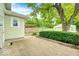 View of the backyard with a concrete patio, mature trees, and a wooden fence for privacy at 5148 Crittenden Ave, Indianapolis, IN 46205
