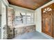 Inviting enclosed front porch featuring wood ceiling, stone accents and a wooden front door at 5148 Crittenden Ave, Indianapolis, IN 46205