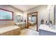 Luxurious bathroom featuring dual vanities, a soaking tub, and a mirrored closet door at 5350 Chico Grey Dr, Indianapolis, IN 46237