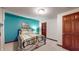 Cozy bedroom with a teal accent wall, plush carpet, and warm wood door at 5350 Chico Grey Dr, Indianapolis, IN 46237