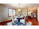 Bright dining space with modern lighting fixture, wood floors, and convenient access to the kitchen at 5350 Chico Grey Dr, Indianapolis, IN 46237