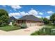 Spacious home with a three-car garage, well-manicured lawn, and mature trees, offering great curb appeal at 5350 Chico Grey Dr, Indianapolis, IN 46237