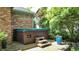Outdoor hot tub on a patio with a privacy wall and lush greenery surrounding the space at 5350 Chico Grey Dr, Indianapolis, IN 46237