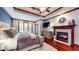 Serene main bedroom features a fireplace, tray ceiling, and a cozy sitting area with backyard views at 5350 Chico Grey Dr, Indianapolis, IN 46237